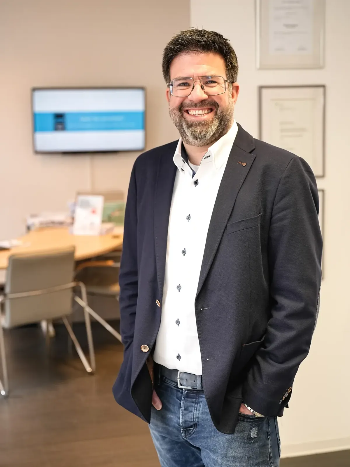 Unternehmer im Sakko steht in seinem Büro