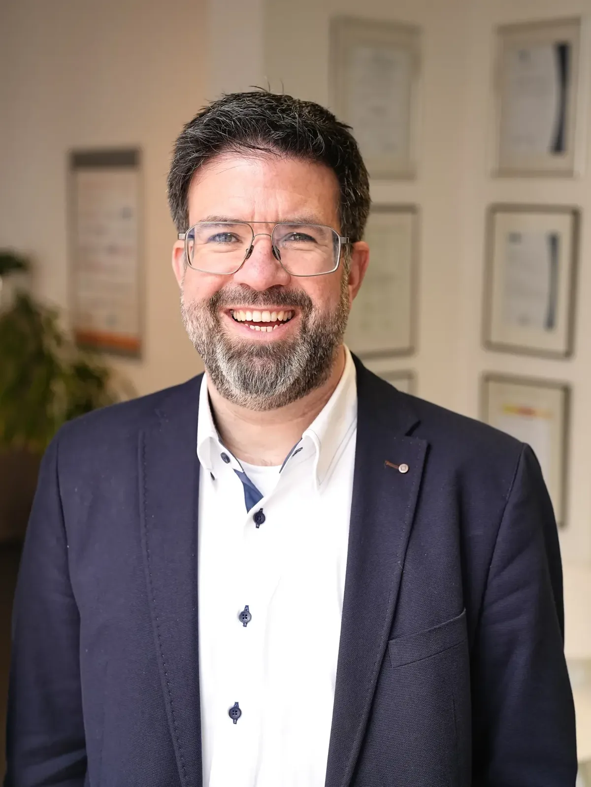 Unternehmer im Sakko lacht in die Kamera